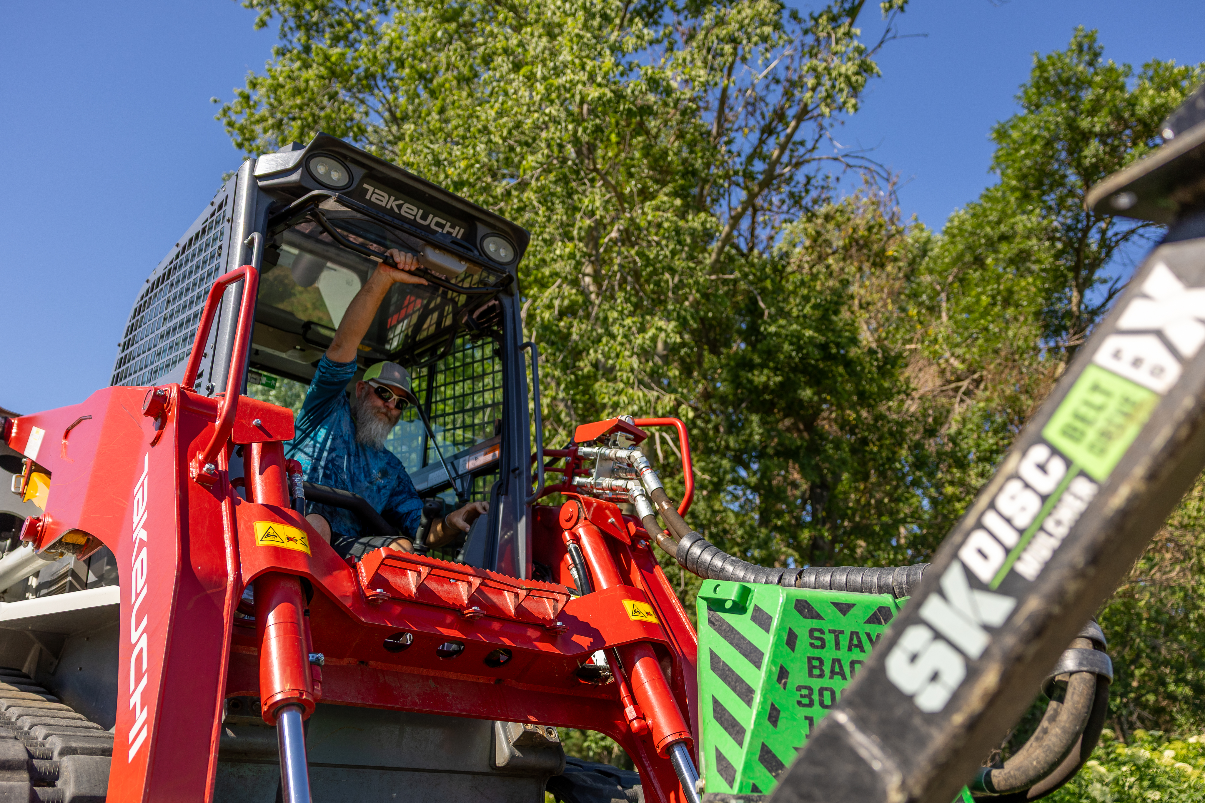 person closing their skid steer door